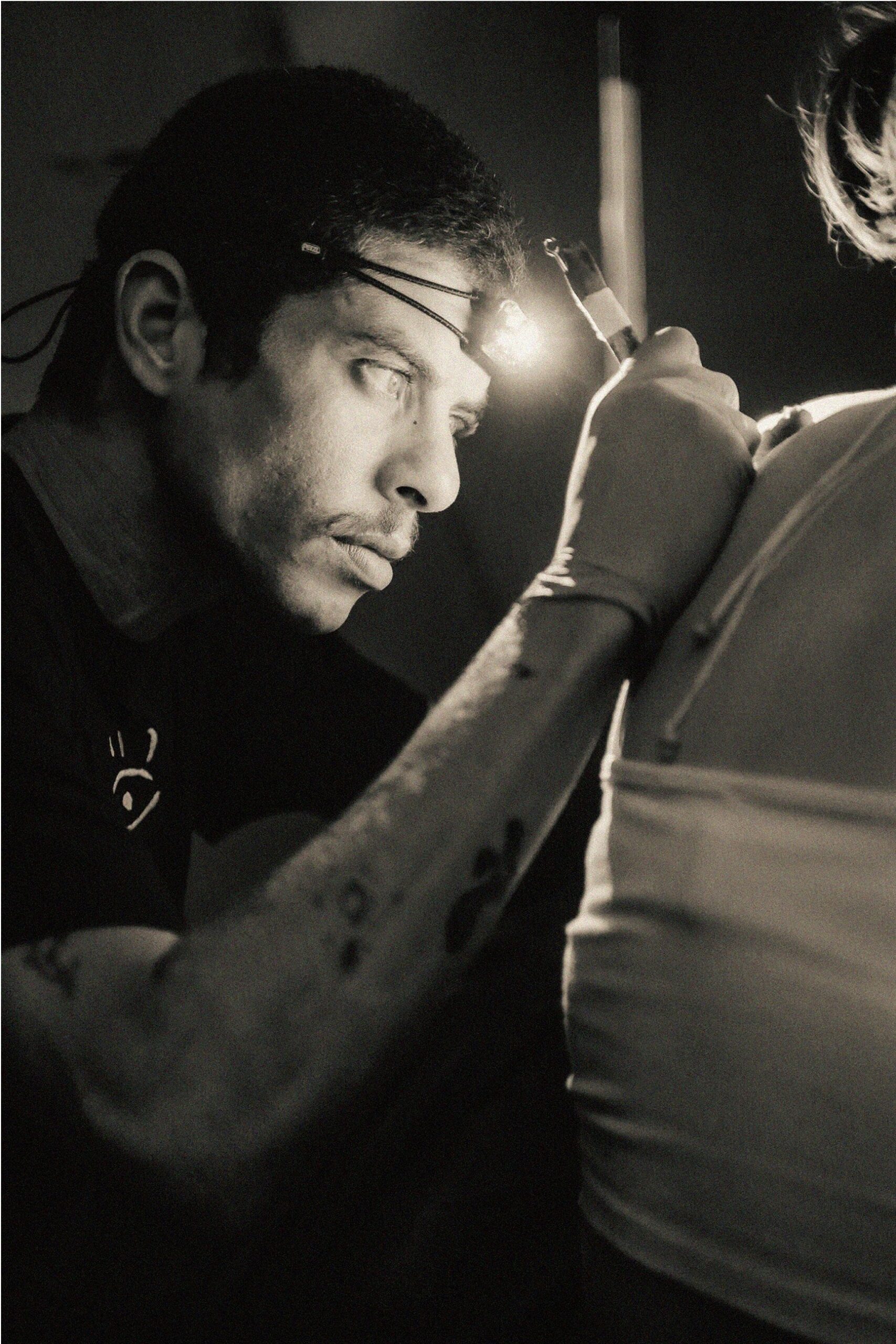 Ilyas doing a poke tattoo on a woman