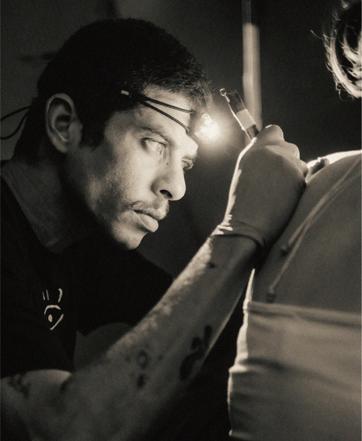 Ilyas doing poke tattoo on a woman client