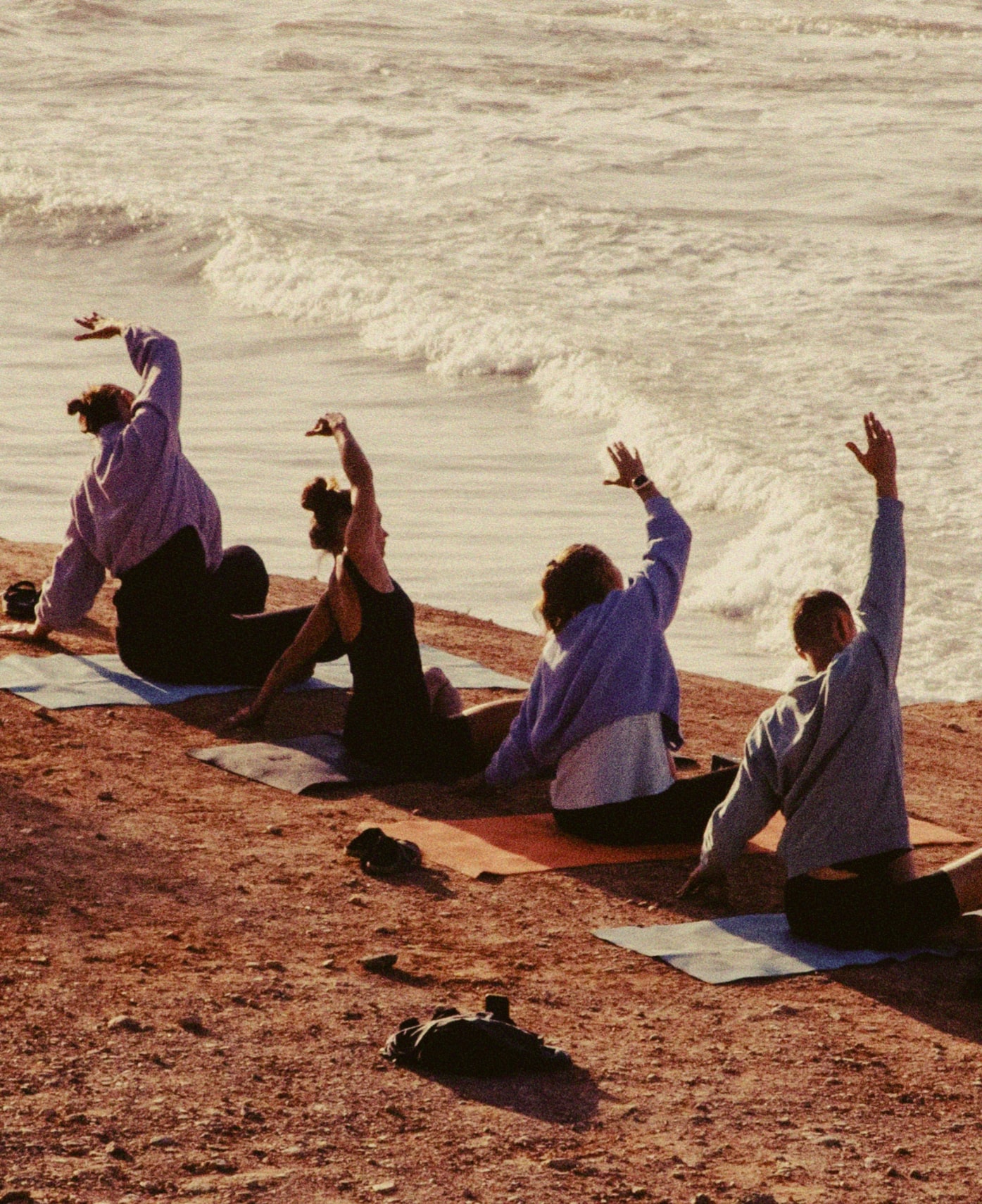 A group of surfers doing yoga on the beach