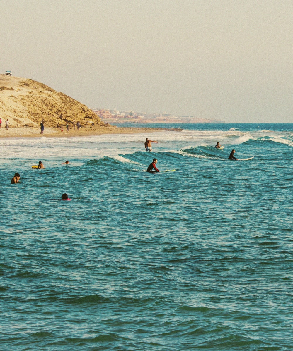 Surfers at Devil's rock surf spot in Tamraght, Morocco